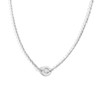 Collar de acero inoxidable plateado  con una medalla pequeña redonda calada en forma de inicial C y cadena forzada