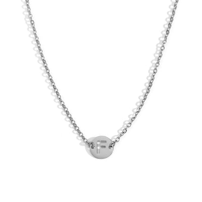 Collar de acero inoxidable plateado  con una medalla pequeña redonda calada en forma de inicial F y cadena forzada