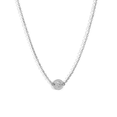 Collar de acero inoxidable plateado  con una medalla pequeña redonda calada en forma de inicial G y cadena forzada