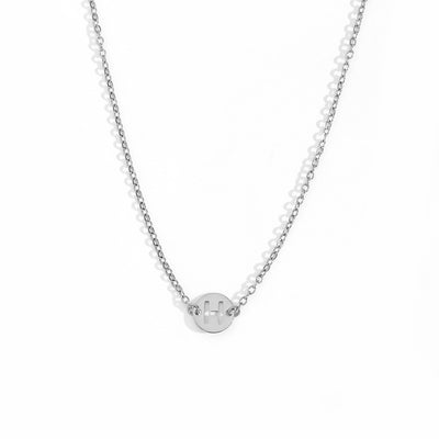 Collar de acero inoxidable plateado  con una medalla pequeña redonda calada en forma de inicial H y cadena forzada