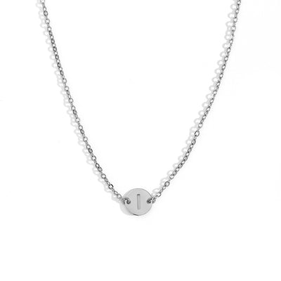 Collar de acero inoxidable plateado  con una medalla pequeña redonda calada en forma de inicial I y cadena forzada