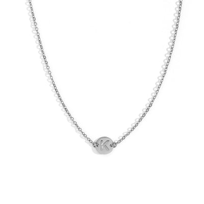 Collar de acero inoxidable plateado  con una medalla pequeña redonda calada en forma de inicial K y cadena forzada