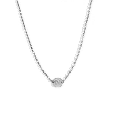 Collar de acero inoxidable plateado  con una medalla pequeña redonda calada en forma de inicial N y cadena forzada