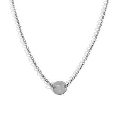Collar de acero inoxidable plateado  con una medalla pequeña redonda calada en forma de inicial T y cadena forzada