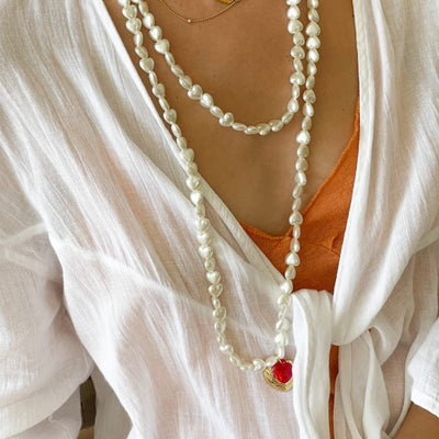 Collar largo de perlas blancas y colgante en forma de corazón